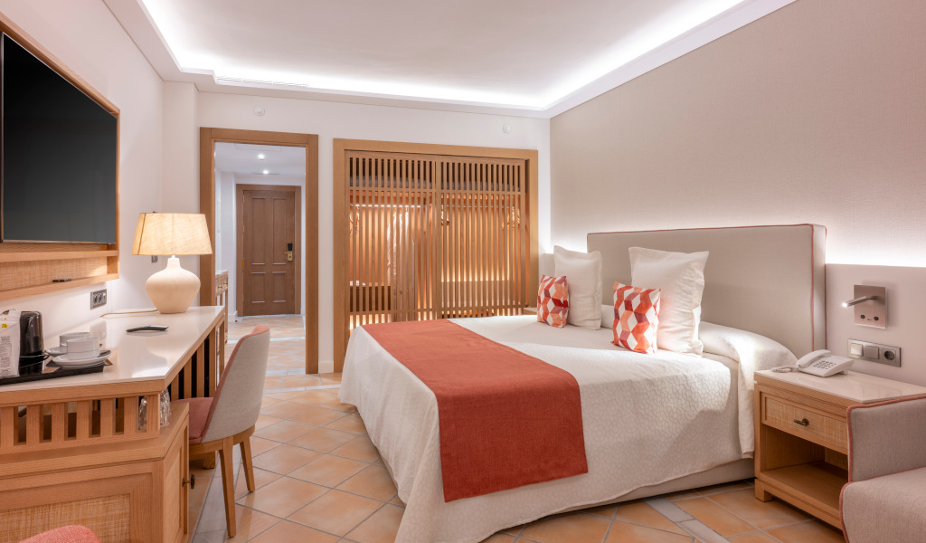 Habitación de hotel en Tenerife con cama doble, escritorio y televisor.