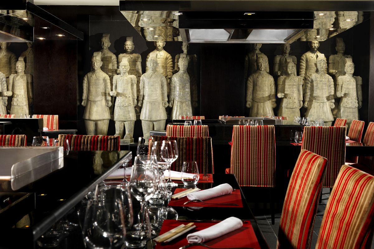 Restaurante en Tenerife con decoración de guerreros de terracota y mesas preparadas.