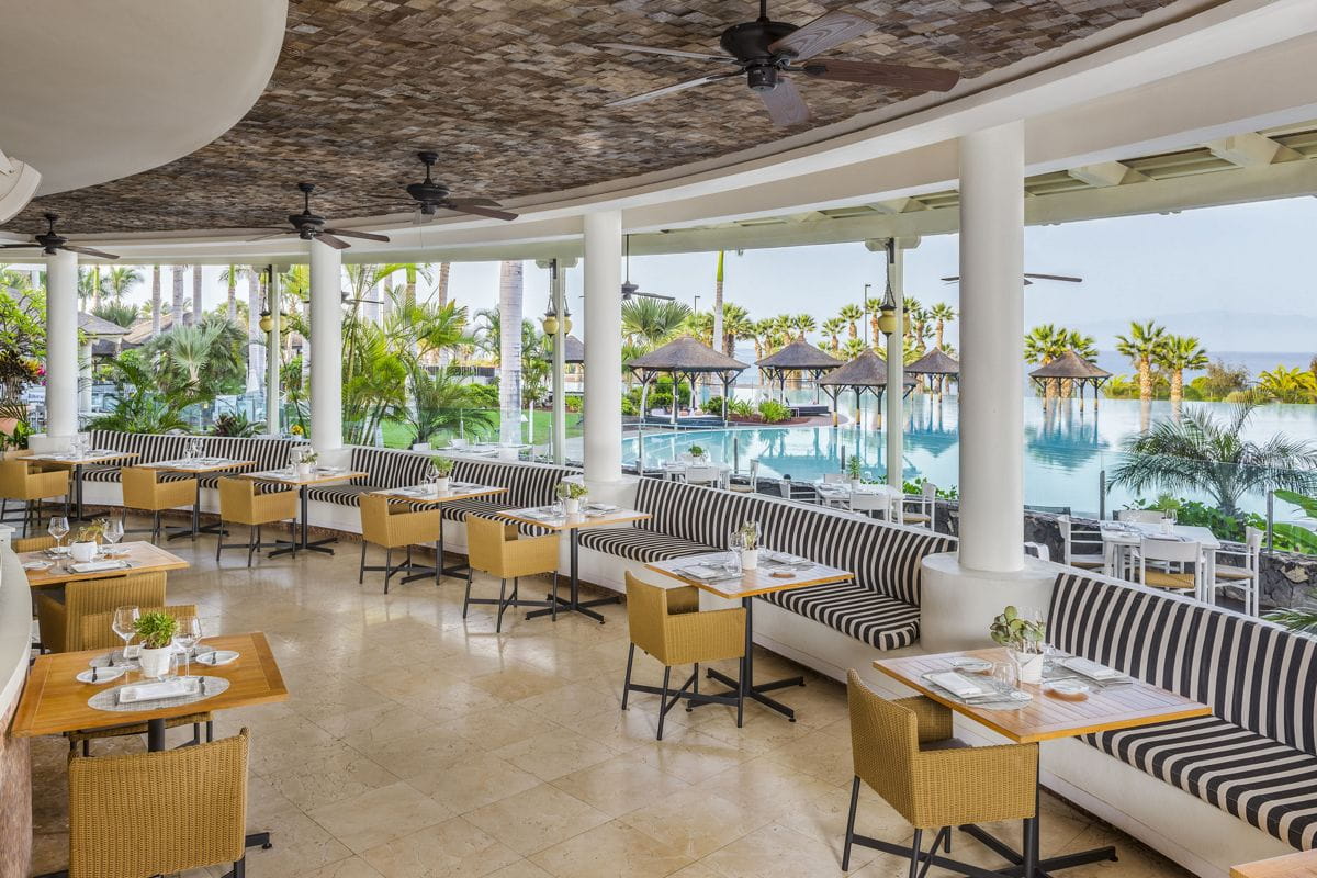 Restaurante con vista a la piscina y palmeras en Tenerife.