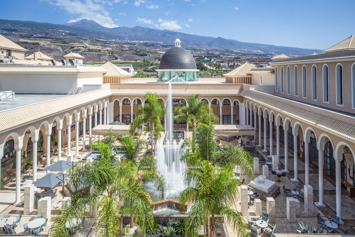 Patio con fuente central y palmeras en complejo turístico de Tenerife.