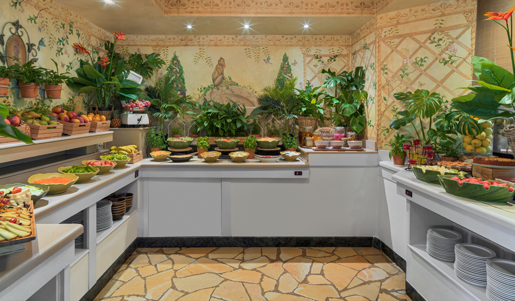 Bufé de frutas y ensaladas en hotel de Tenerife con decoración natural.