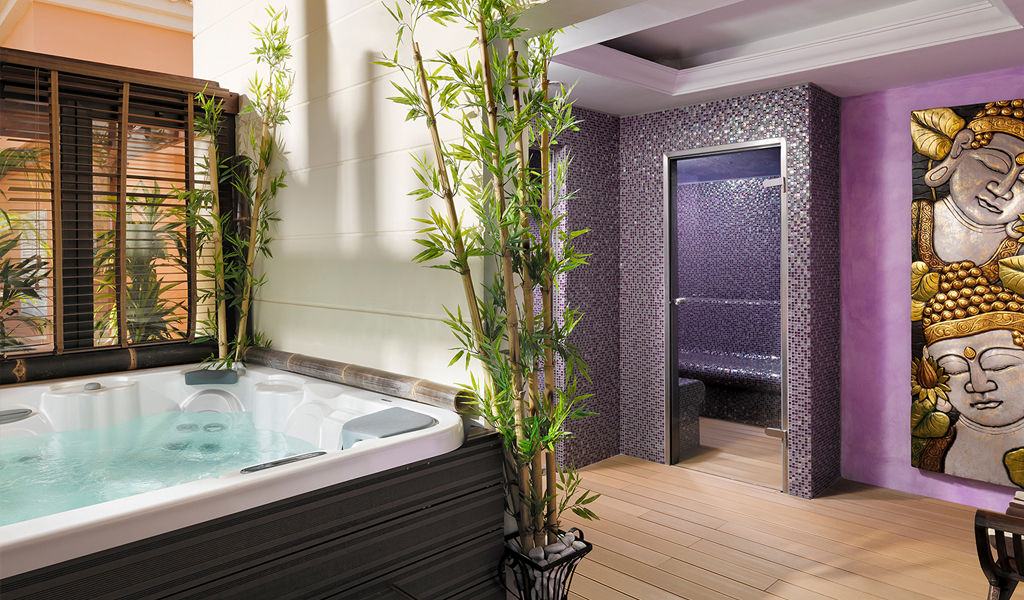 Jacuzzi y sala de vapor en un spa en Tenerife, decorados con bambú y arte en una pared.