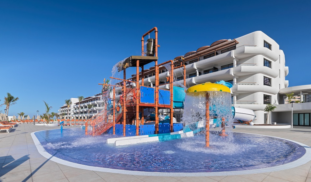 Zona de juegos acuática en un hotel en Tenerife con toboganes y estructura de colores.