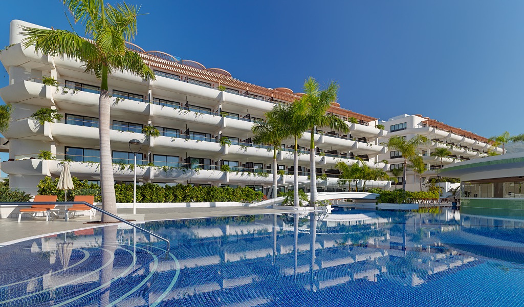 Hotel moderno con piscina rodeado de palmeras en Tenerife.