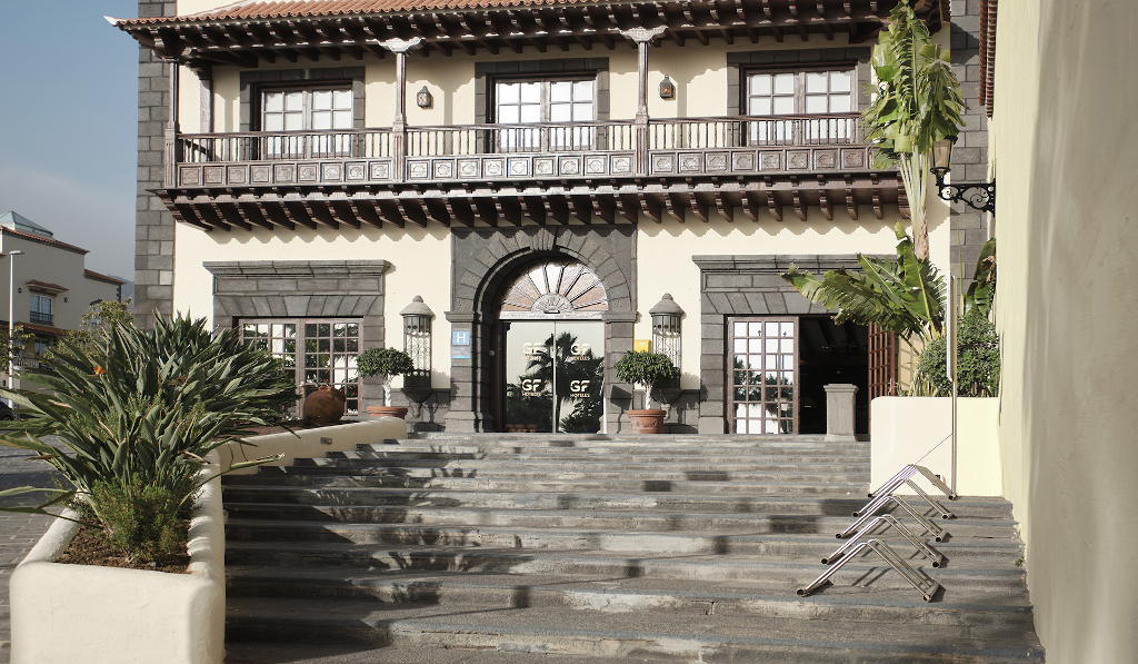 Entrada principal de un edificio con escaleras y plantas en Tenerife.
