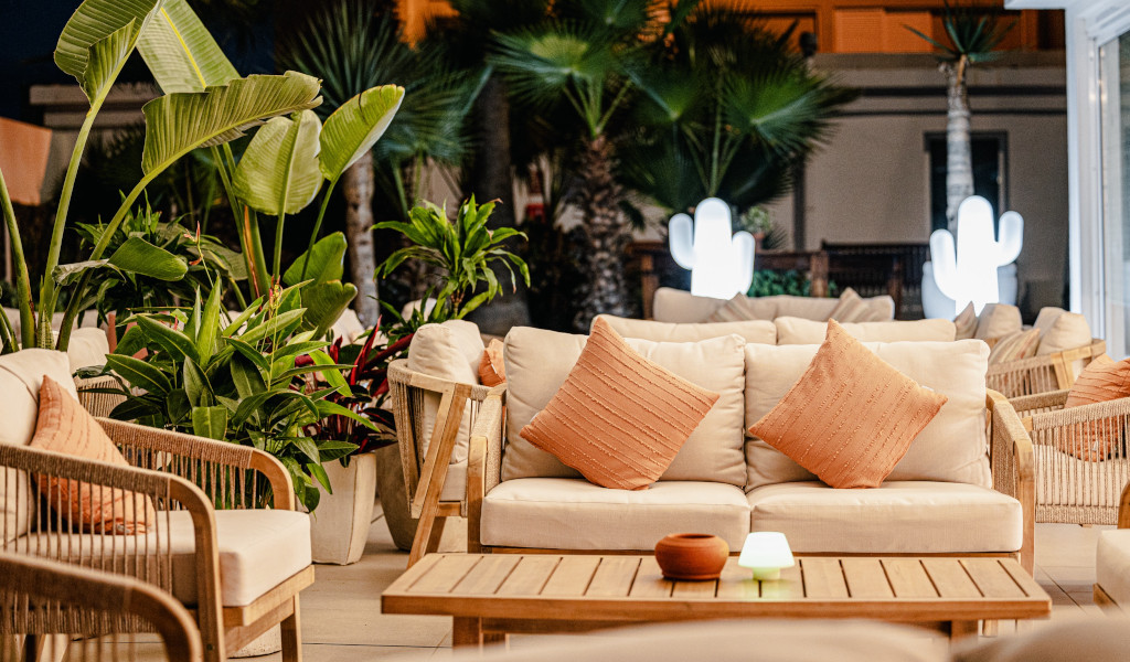 Muebles de exterior con plantas tropicales en terraza nocturna en Tenerife.