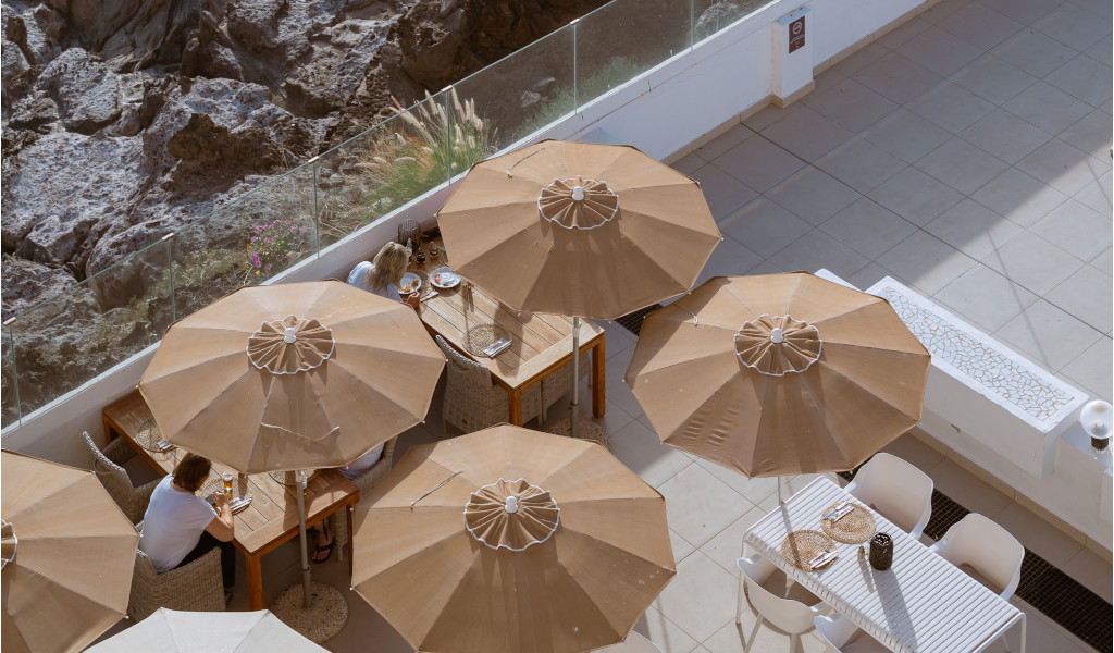 Terraza con mesas y sombrillas en Tenerife, vista desde arriba.