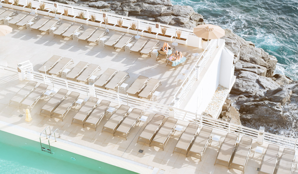 Sillas de playa junto a la piscina y el mar en Tenerife.