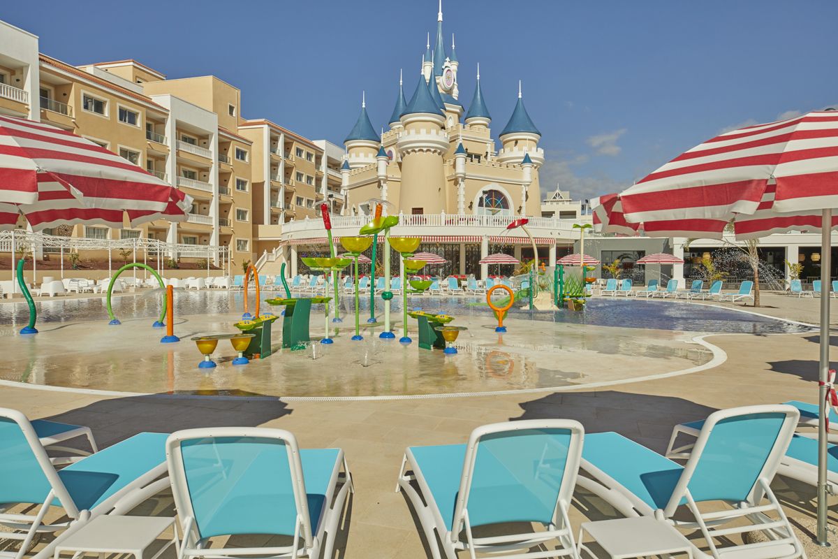 Piscina infantil con juegos acuáticos y castillo en un hotel en Tenerife.