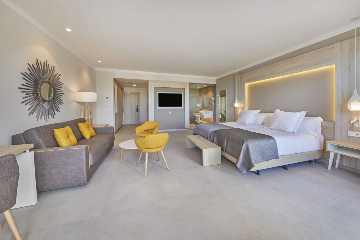 Habitación de hotel moderna con cama, sofá y decoración en Tenerife.