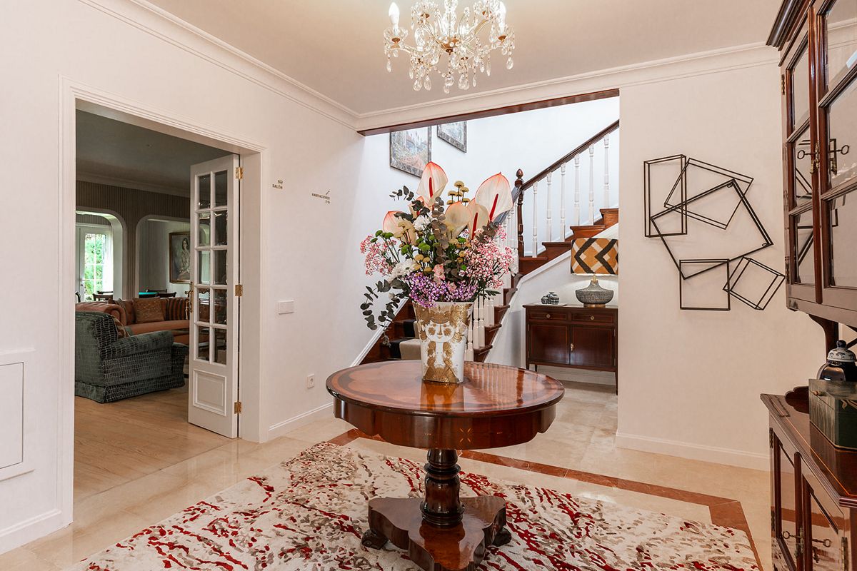 Vestíbulo elegante con mesa central y escalera en una casa de Tenerife.