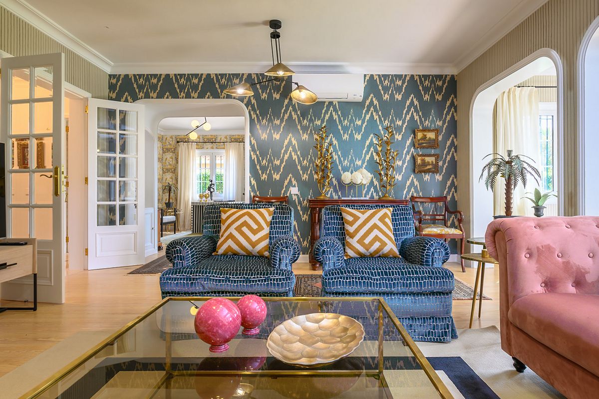 Sala de estar con sofás azules y mesa de cristal en Tenerife.