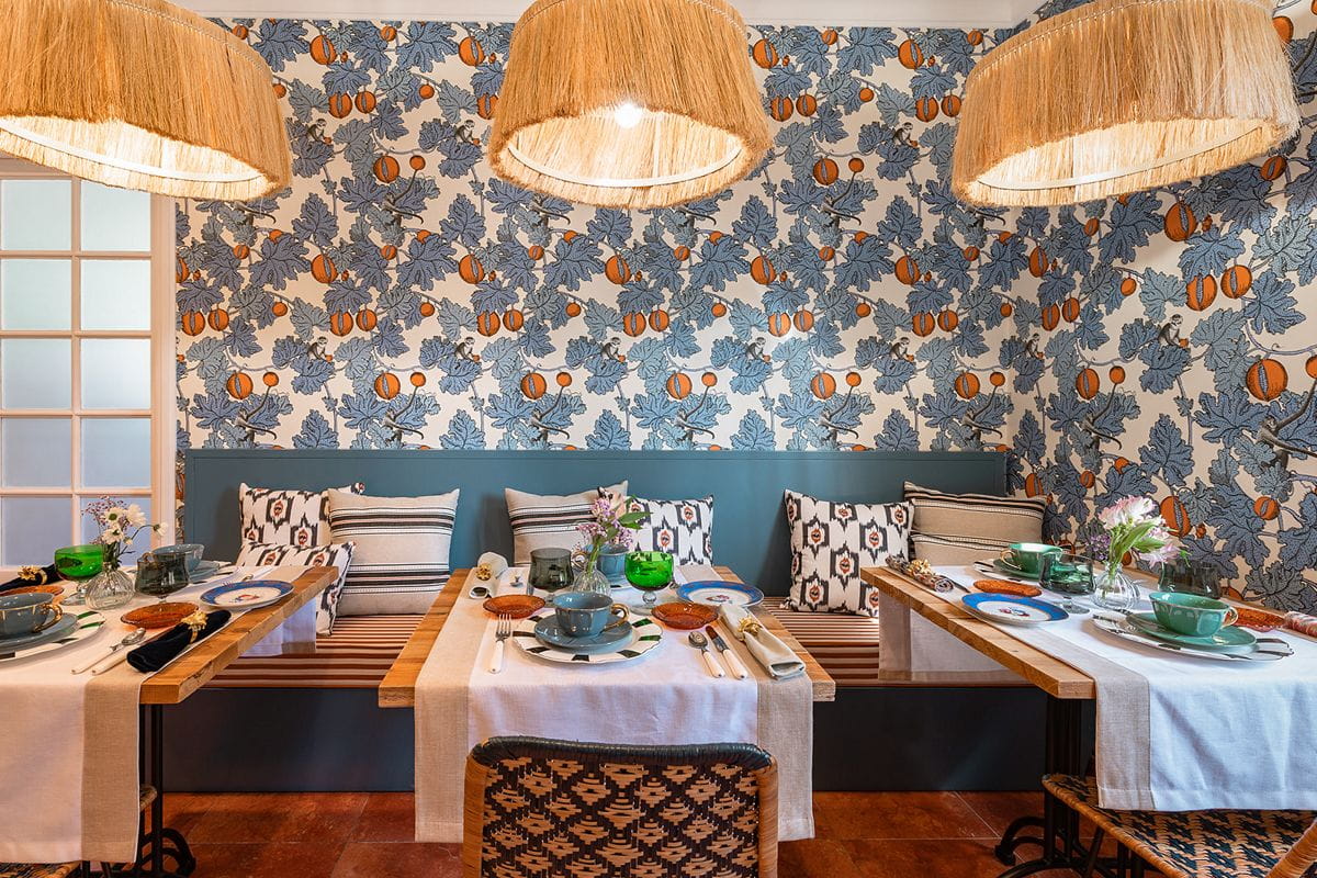 Restaurante en Tenerife con mesas puestas, decorado con papel floral y luces colgantes.