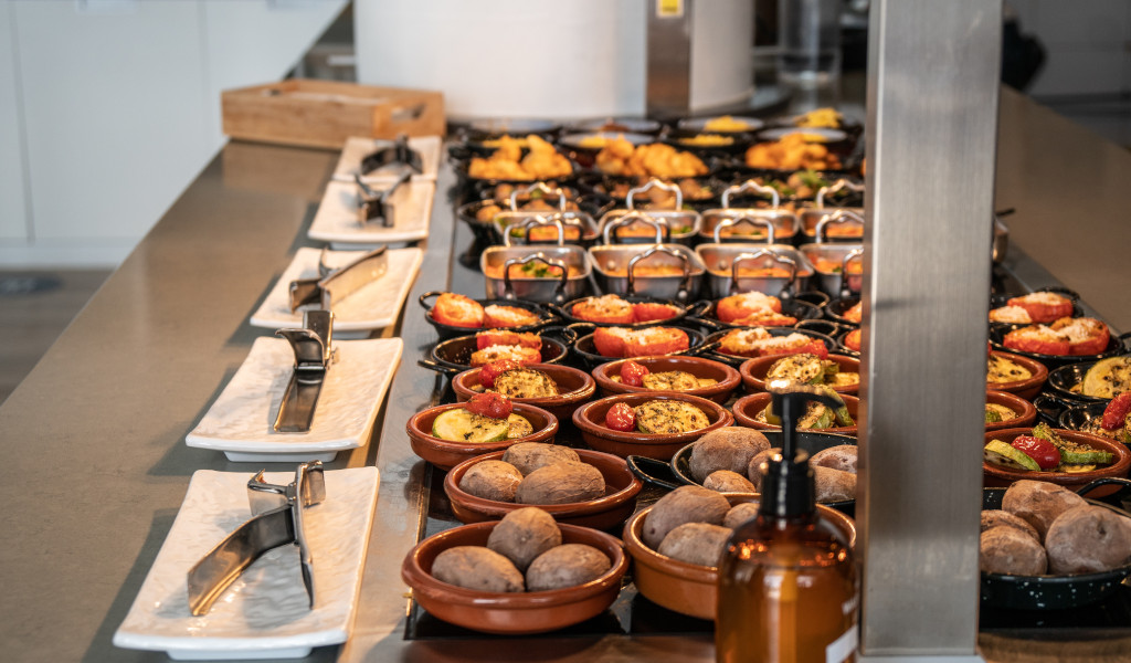 Platos con papas arrugadas y tapas variadas en bufé en Tenerife.