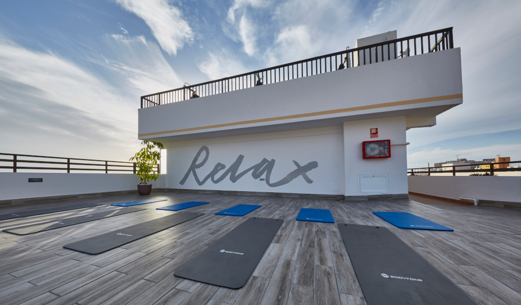Azotea con colchonetas de yoga y la palabra Relax en la pared en Tenerife.