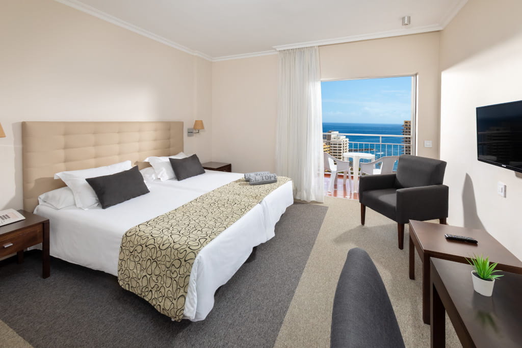 Habitación de hotel en Tenerife con vista al mar desde el balcón.