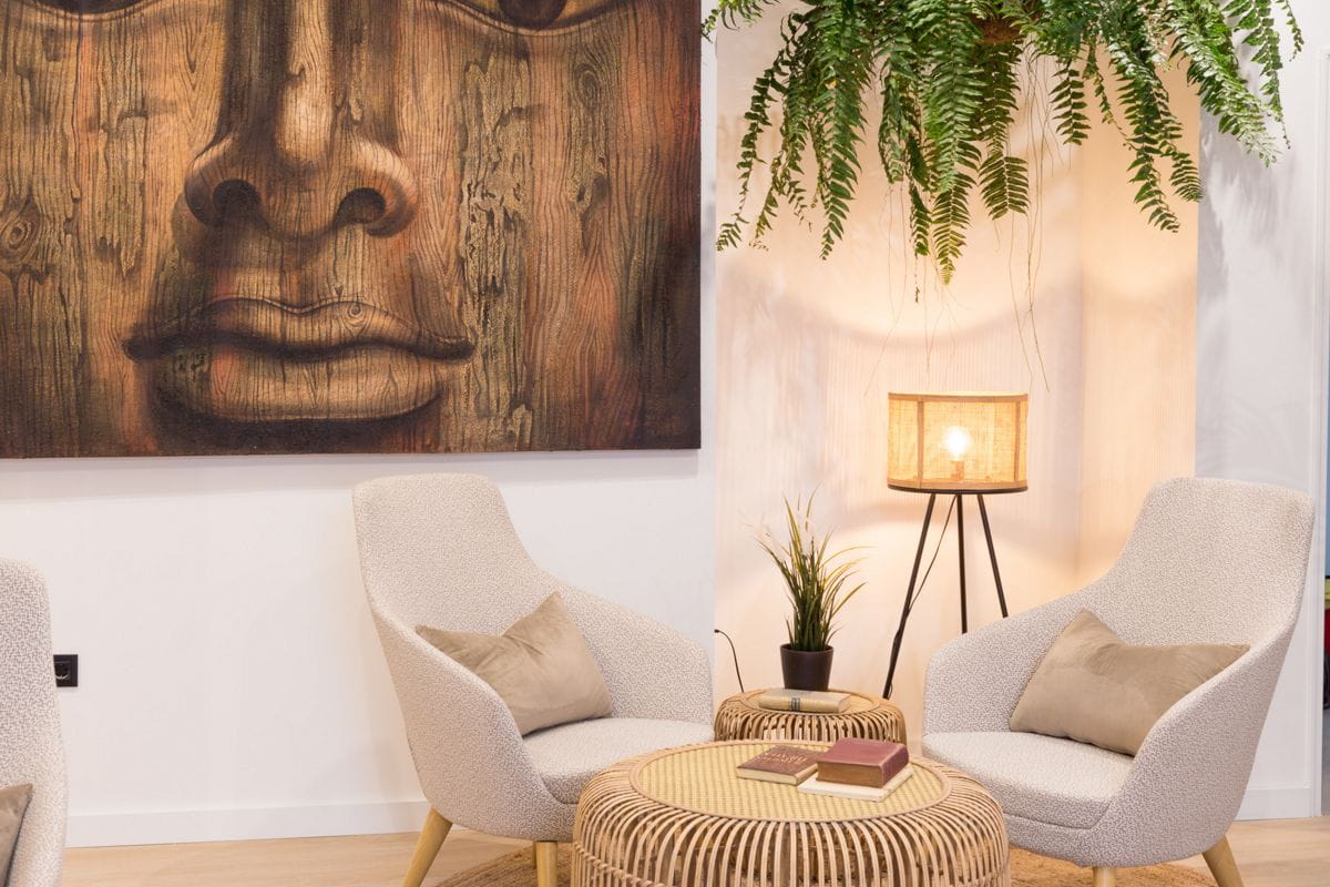 Sala de estar con sillas, mesas y cuadro de madera. Decoración de Tenerife.
