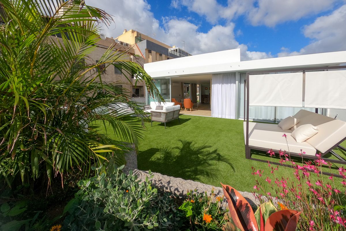 Terraza con césped, muebles de exterior y plantas en Tenerife.