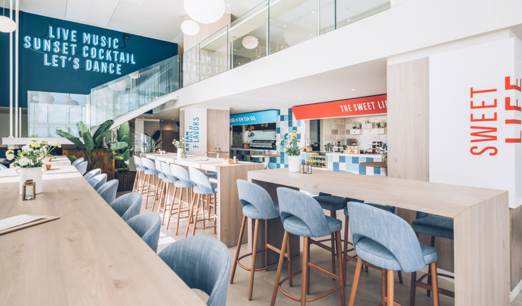 Interior de cafetería con sillas azules y decoración moderna en Tenerife.