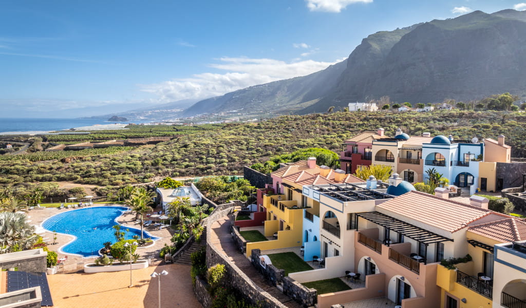 Complejo turístico con piscina y vistas al paisaje montañoso de Tenerife.