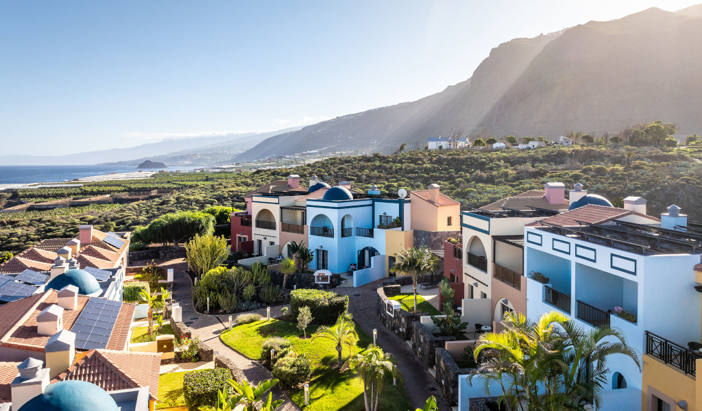Complejo de edificios coloridos con vista a la montaña y al mar en Tenerife.