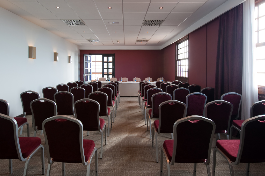 Sala de conferencias con sillas y mesa al fondo en Tenerife.