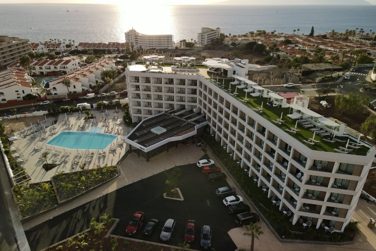 Hotel en Tenerife con piscina y vista al mar al atardecer.