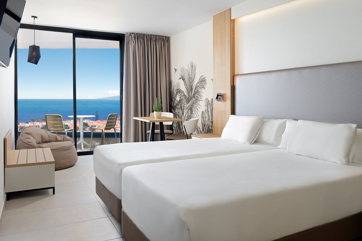 Habitación moderna con camas dobles y vista al mar en Tenerife.
