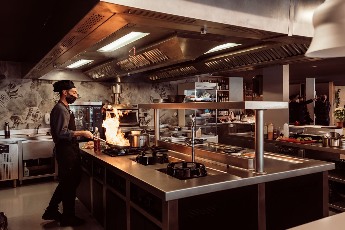 Chef cocinando con llamas en una cocina en Tenerife.