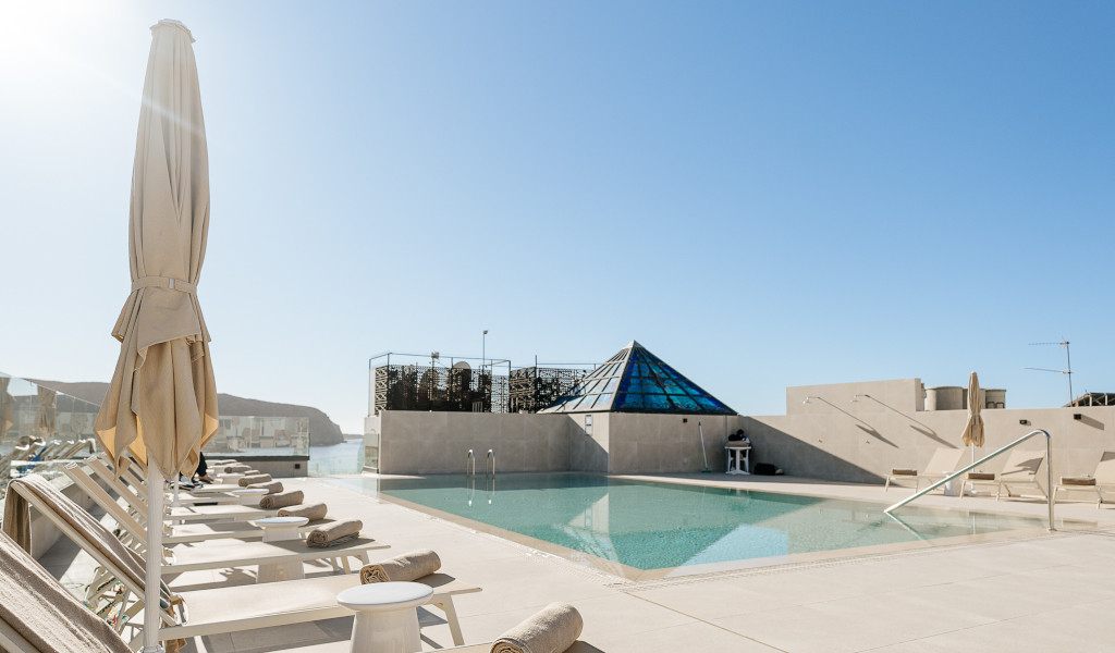 Piscina con tumbonas y sombrillas en un hotel de Tenerife.