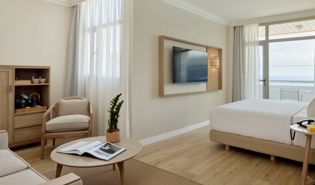 Habitación con cama, televisor y vista al mar en Tenerife.