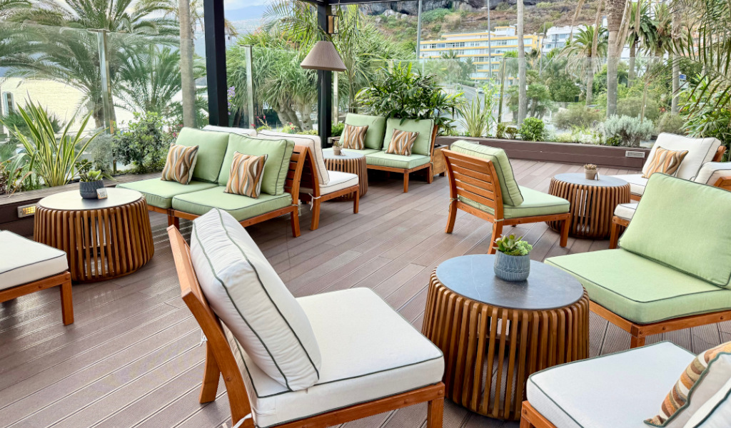 Terraza con muebles de madera y cojines verdes en Tenerife.