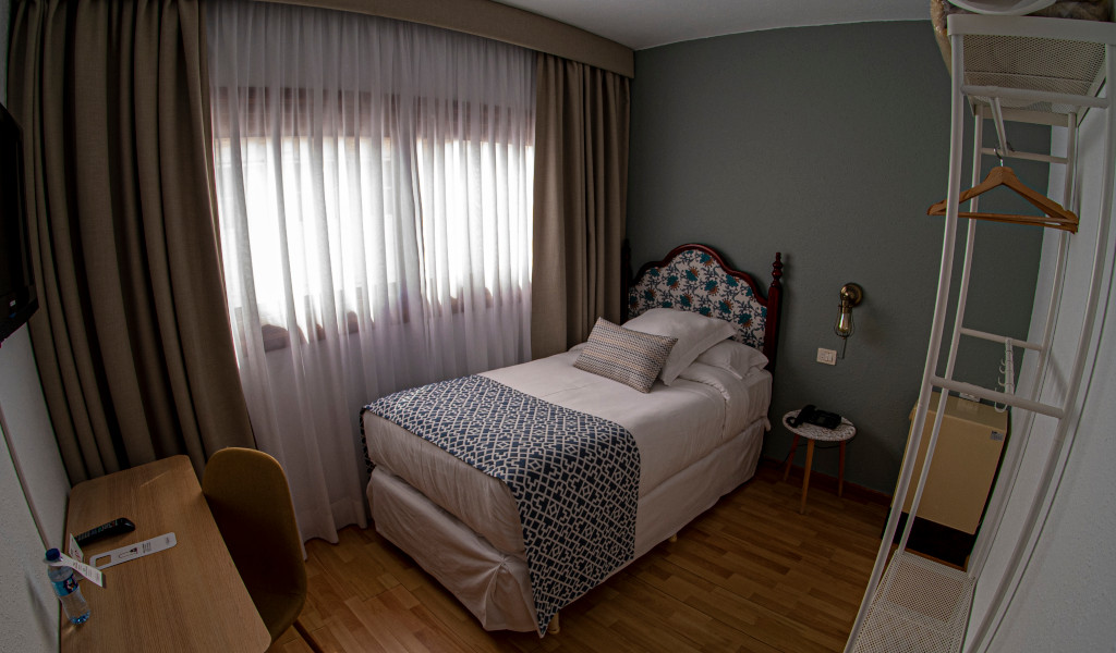 Cama individual en una habitación acogedora con escritorio en Tenerife.