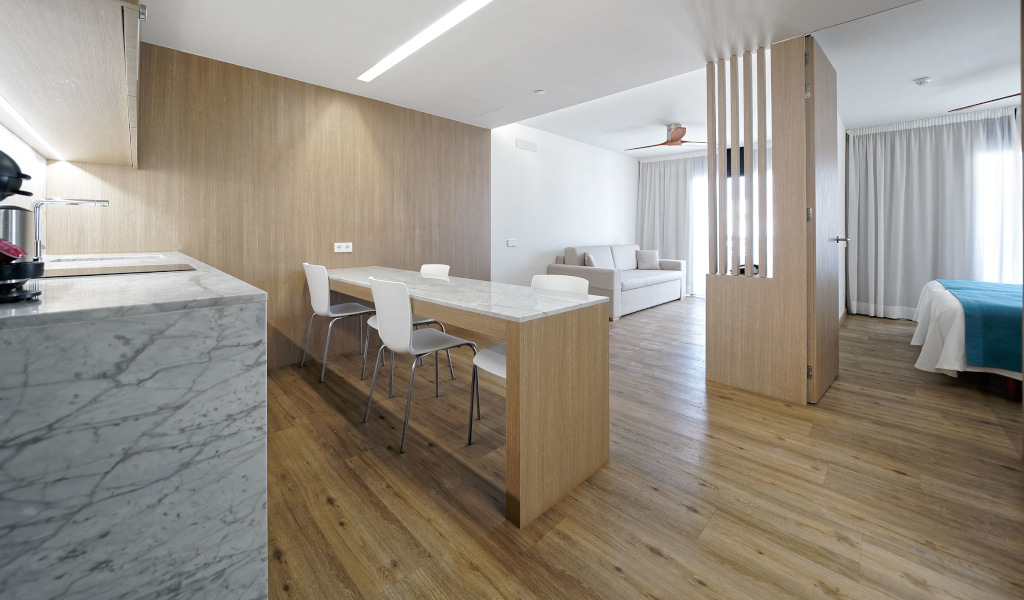 Cocina y comedor con mesa de mármol en apartamento en Tenerife.