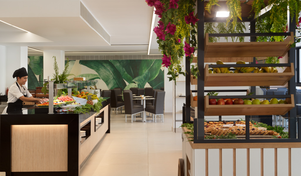 Cocinero sirviendo frutas y panes en un buffet en Tenerife.