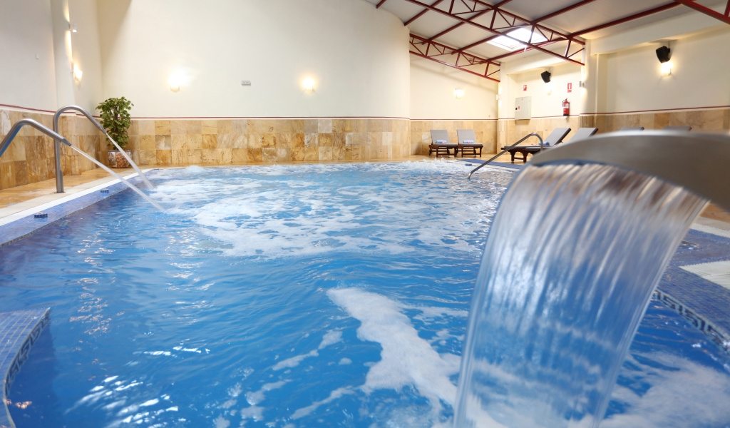 Piscina interior con cascada de agua en spa de Tenerife.