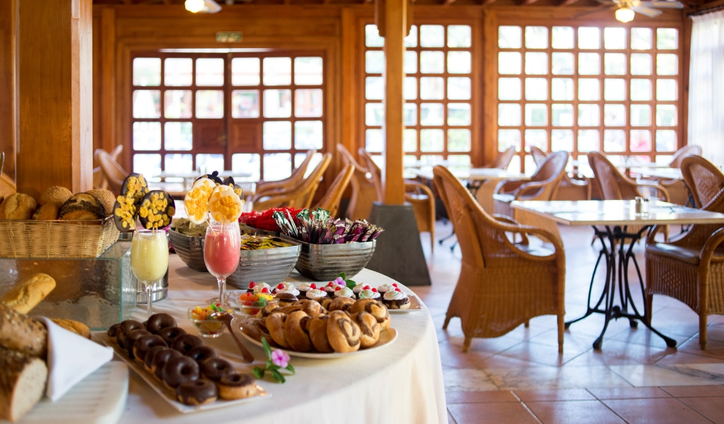 Mesa de desayuno con bollería y jugos en un restaurante en Tenerife.