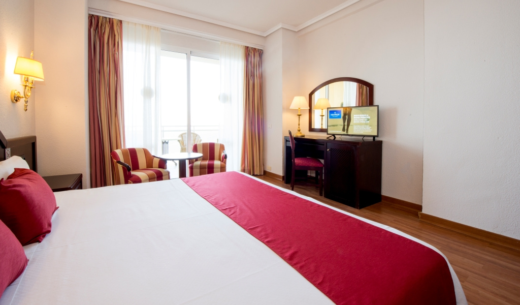 Habitación de hotel con cama grande, escritorio y vista en Tenerife.