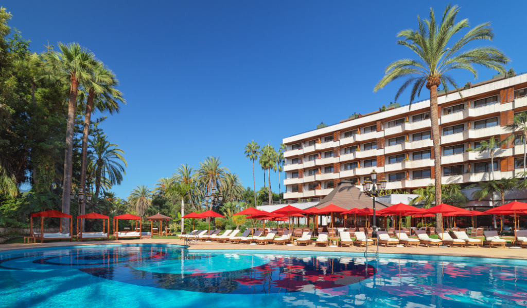 Piscina y hotel rodeados de palmeras en Tenerife.
