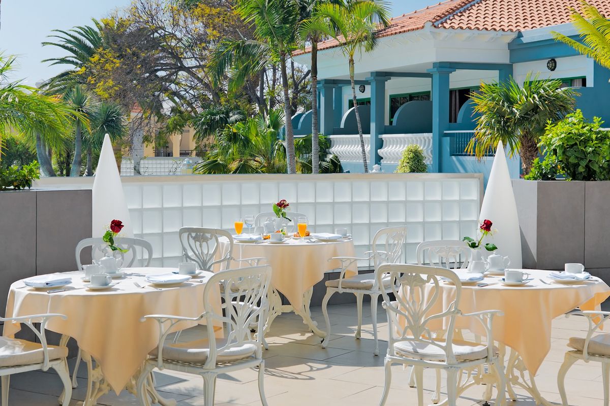 Mesas al aire libre con vajilla y jugo en un restaurante de Tenerife.