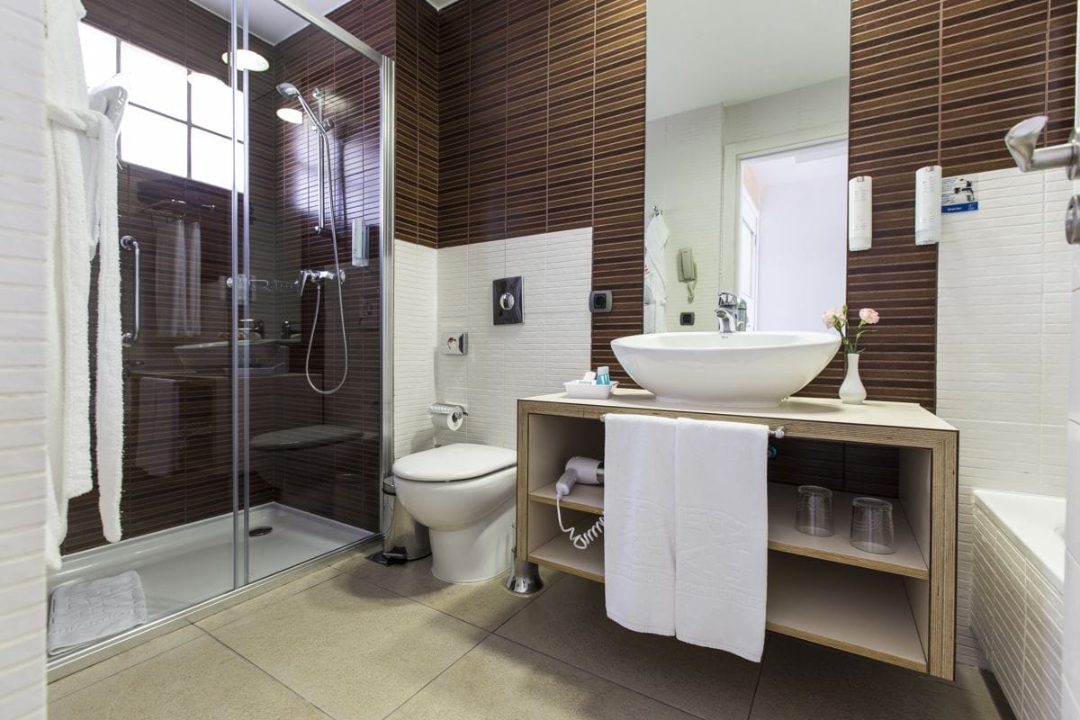Baño moderno con ducha, lavabo y toallas en un hotel en Tenerife.