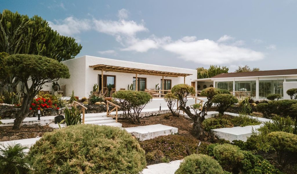 Casa blanca con jardín y terraza en Tenerife bajo cielo azul.