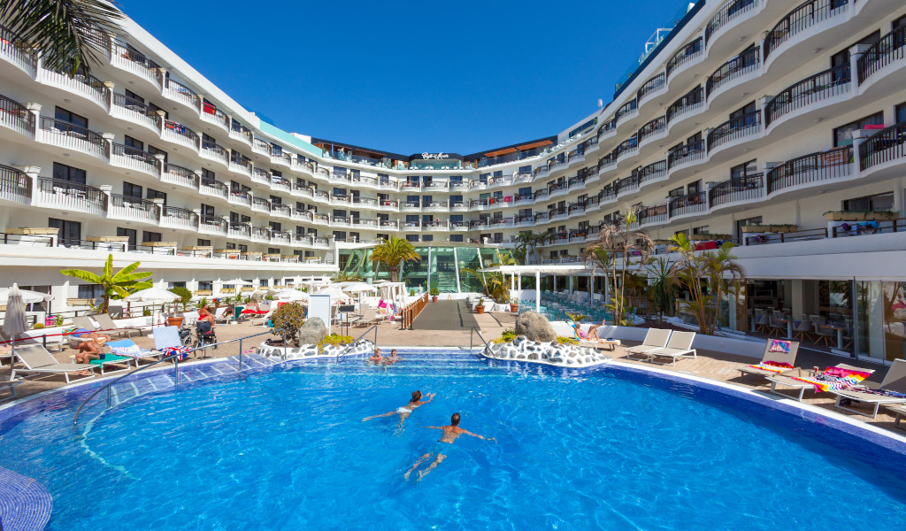 Piscina del hotel en Playa de las Américas, Tenerife, con huéspedes nadando.