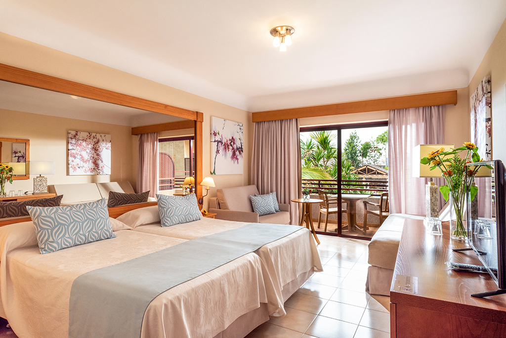 Habitación de hotel con balcón con vistas a jardín en Tenerife.