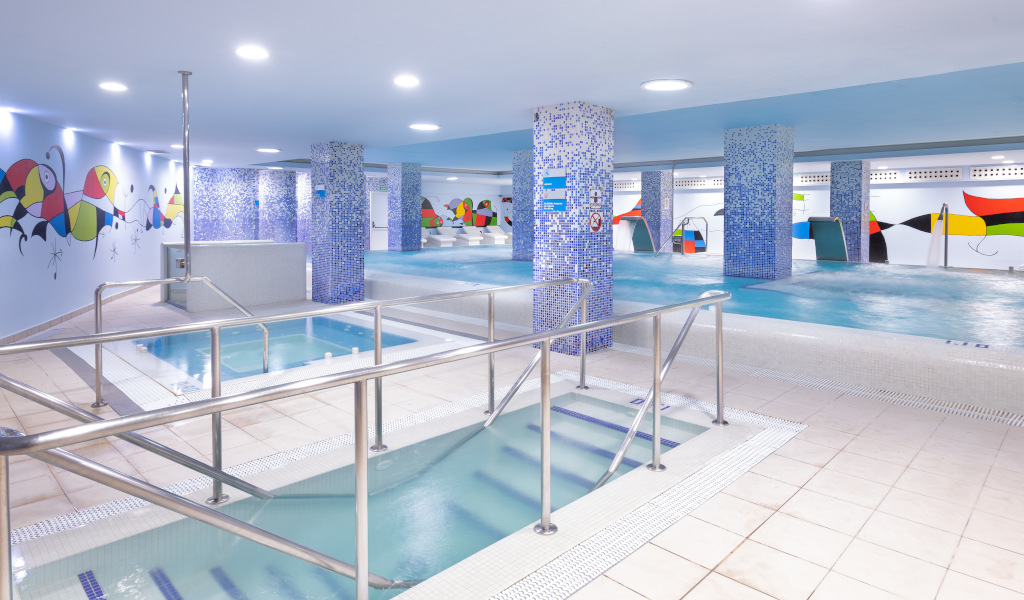 Piscina interior con murales coloridos y zona de jacuzzi en Tenerife.
