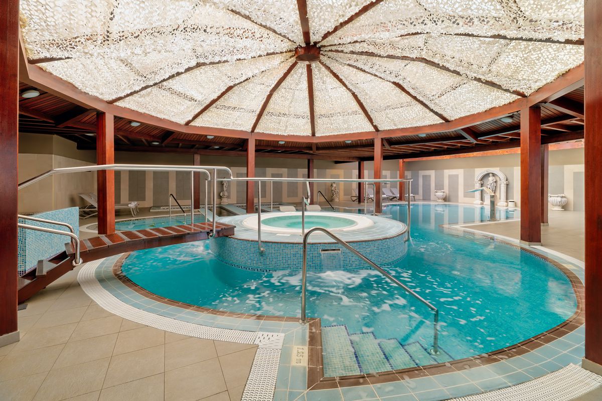 Piscina cubierta con jacuzzi en un spa de Tenerife con estructura de madera.