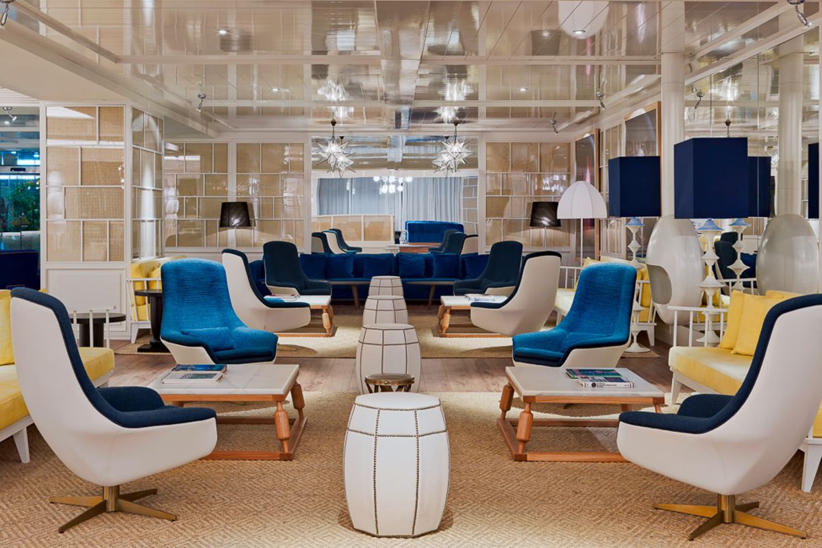 Espacio lounge con sillones azules y mesas en un hotel de Tenerife.