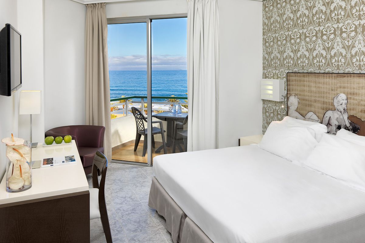 Habitación de hotel en Tenerife con vistas al mar desde el balcón.