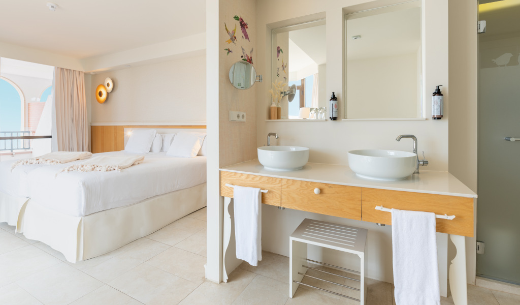 Habitación luminosa con cama doble, baño moderno y vista al mar en Tenerife.