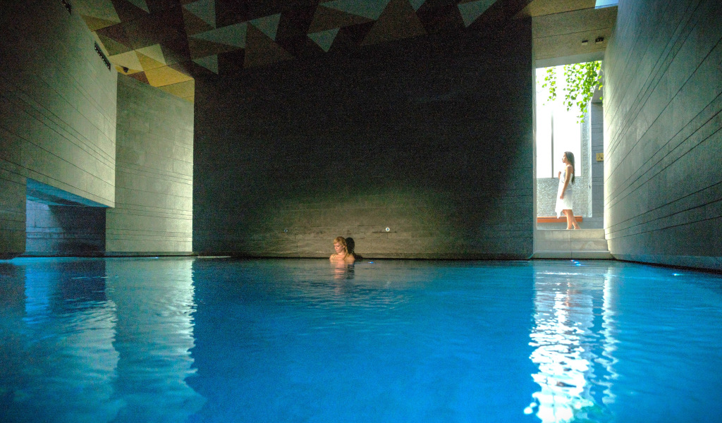 Piscina interior con mujer entrando, diseño moderno en Tenerife.